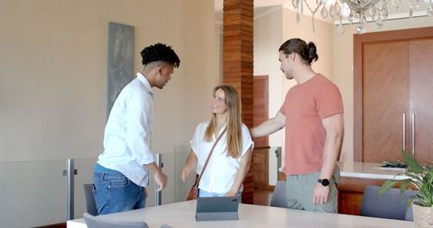 Friends Gathering and Chatting Around Tablet in Modern Living Room