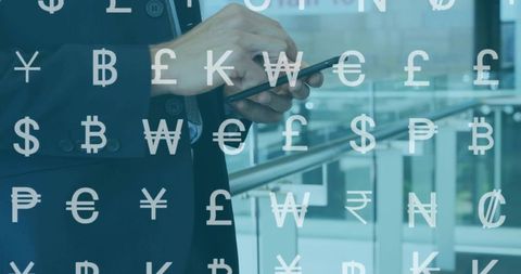 Executive tapping smartphone with currency symbols overlay in glass atrium, fintech concept