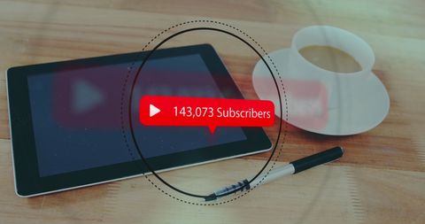 Digital tablet with subscribers count and coffee on desk
