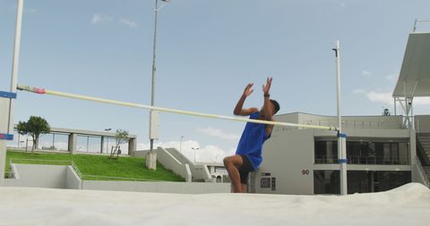 Athlete Mid-Air During High Jump at Outdoor Stadium - Download Free Stock Images Pikwizard.com