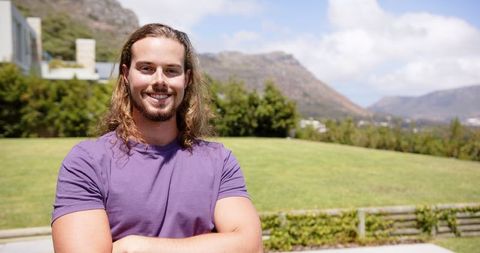 Confident Young Man Smiling Outdoors in Sunny Garden