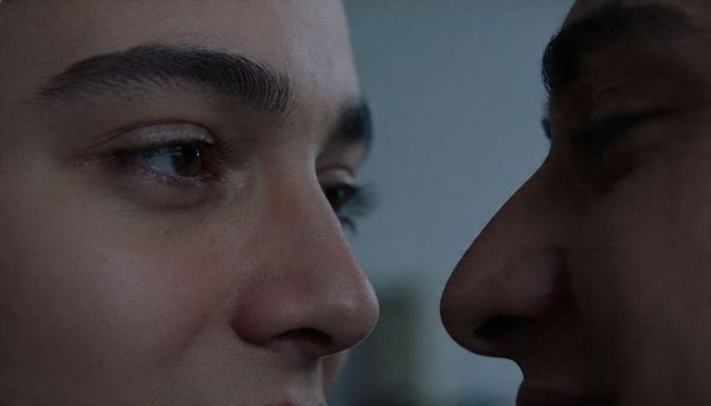 Intense closeup of two men facing each other deep eye contact and emotional tension