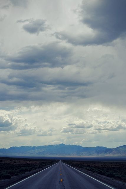 Desert Highway Stretching Towards Mountains with Dramatic Skies - Download Free Stock Photos Pikwizard.com