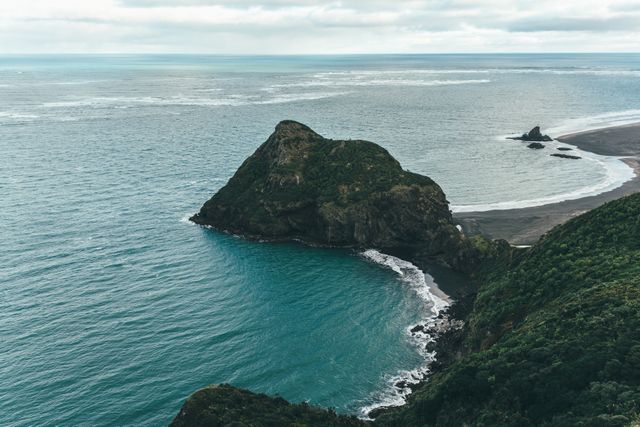 Photo showcases a stunning coastal cliff surrounded by turquoise ocean water. Perfect for travel websites, environmental awareness campaigns, or nature-themed content. Captures the essence of unspoiled natural beauty, ideal for use in tourism brochures, blogs, and on social media to evoke a sense of adventure and tranquility.