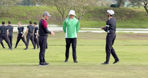 Athletes discussing cricket tactics on field