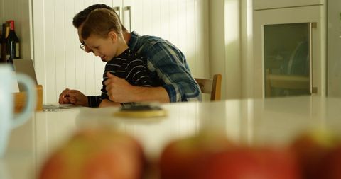 Dedicated student studying online in home kitchen setting