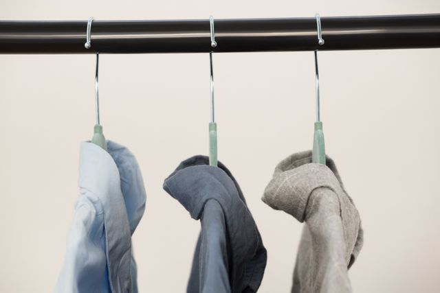 Close-up of shirts hanging on hanger against white wall