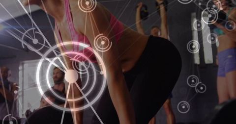 Female athlete deadlifting with analytics hud overlay during group strength training