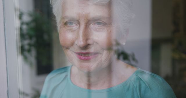 Senior Woman Smiling Through Glass Window at Home - Download Free Stock Images Pikwizard.com