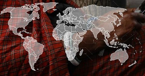 Holding smartphone with red plaid shirt and wristwatch showing digital world map overlay