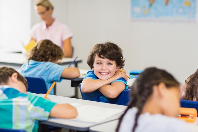 Smiling boy looking at camera during lesson in classroom