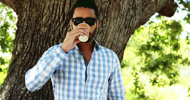 Man in Sunglasses Drinking Coffee Outdoors Under Tree - Download Free Stock Images Pikwizard.com