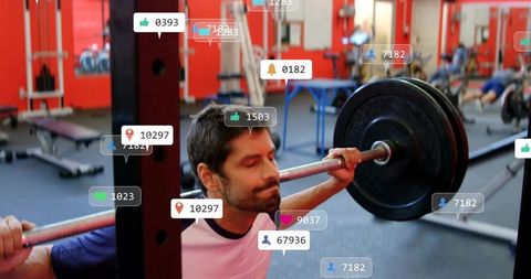 Bearded man squatting heavy barbell in gym with social media notification overlays