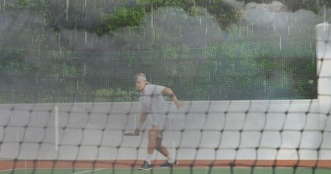Athlete playing tennis under rain