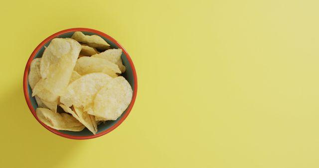 Close up of potato chips in a bowl with copy space on yellow surface - Download Free Stock Photos Pikwizard.com