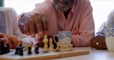 Elderly Couple Enjoying Enthusiastic Chess Match at Cozy Gathering