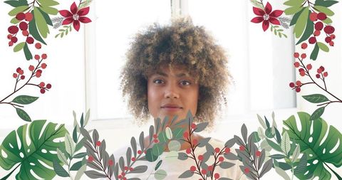 Sunlit curly hair portrait framed by festive botanical foliage for holiday campaigns