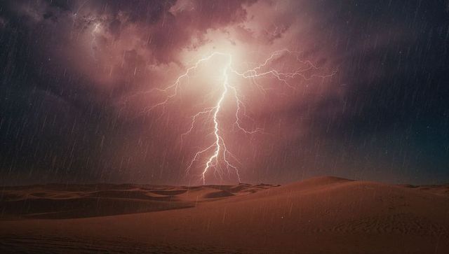 Lightning bolt over desert dunes amidst stormy skies