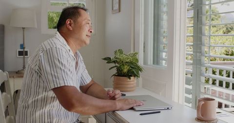 Senior Man Enjoying Daylight At Home Office With laptop