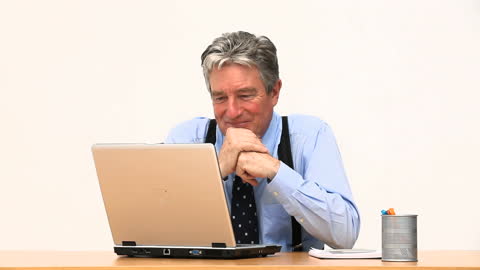 Businessman Smiling at Laptop in Office Setting