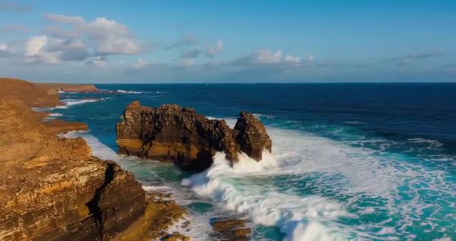 Coastal Waves Crashing Rocks Along Sandstone Cliffs