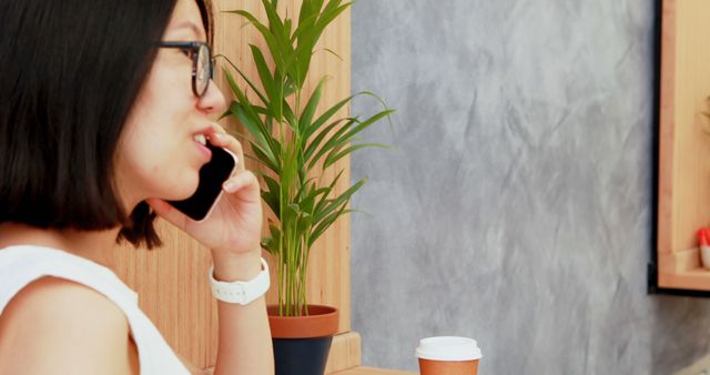 Woman Talking on Mobile Phone in Office with Coffee Cup on Desk - Download Free Stock Images Pikwizard.com