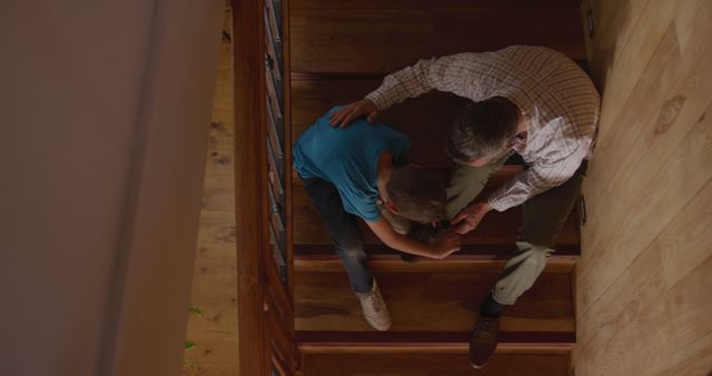 Father Comforting Son on Wooden Staircase in Cozy Home - Download Free Stock Images Pikwizard.com