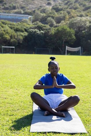 Teen Practising Lotus Pose Yoga Outdoor on Soccer Field