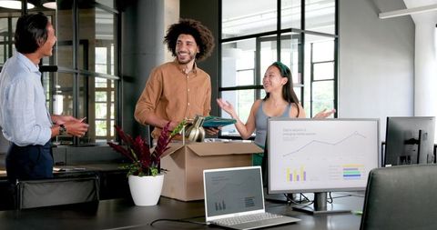 Diverse team bonding unpacking office supplies increase morale