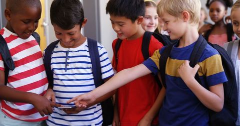 Cheerful School Kids Sharing Smartphone Experience in Corridor - Download Free Stock Images Pikwizard.com