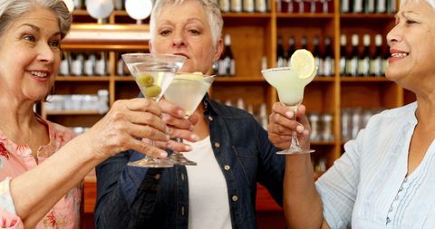 Senior Women Celebrating Friendship with Cocktails at Bar