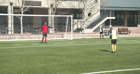 Soccer Players Practicing for Upcoming Match on Field