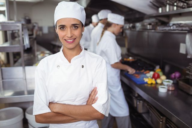 Confident Chef Standing with Arms Crossed in Commercial Kitchen - Download Free Stock Photos Pikwizard.com