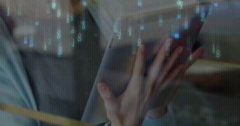 Businesswoman using tablet surrounded by digital binary codes