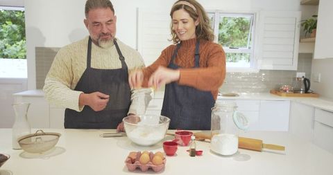 Couple Cracking Eggs Baking Together in Rustic Kitchen
