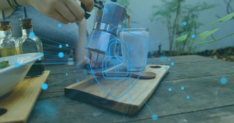 Woman pouring moka espresso into glass on outdoor wood table with digital security shield