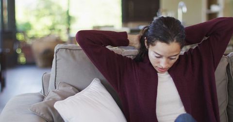 Woman Relaxing on Sofa at Home Enjoying Leisure Time