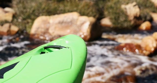 Close-up of a green kayak on a river, outdoor adventure scene. Kayaking enthusiasts often seek the thrill of navigating through rapid waters.