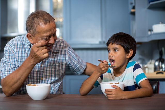 Grandfather and grandson having breakfast at home
