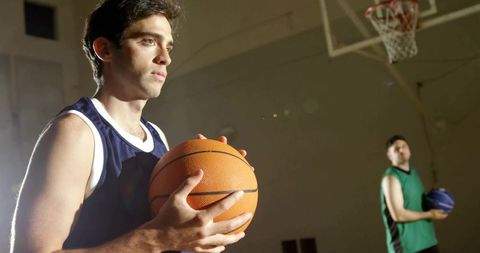 Determined Athlete Holding Basketball in Indoor Gym
