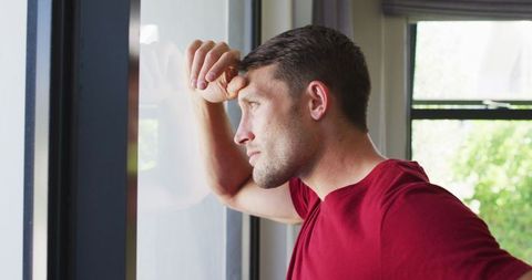 Contemplative Man Gazing Out of Window in Quiet Reflection