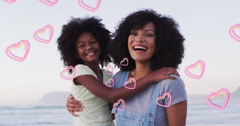 Joyful Mother and Daughter on Beach with Love Hearts