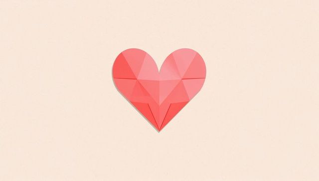 Origami low-poly heart sitting on pale-peach backdrop with soft drop shadow