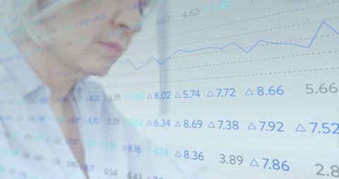 Senior analyst reviewing financial data with graph overlay