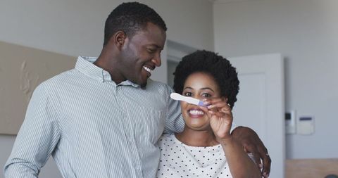 Excited Couple Celebrating Positive Pregnancy Test Result