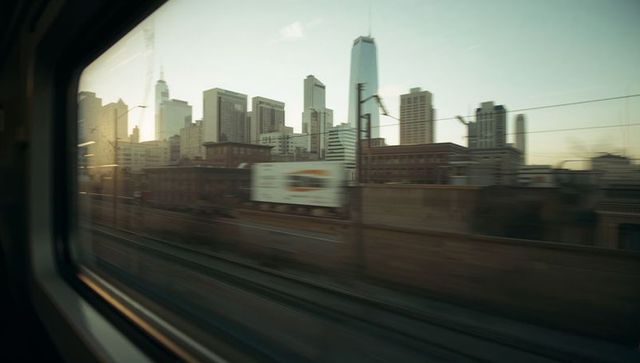 Urban skyline passing by train window at dusk with motion blur