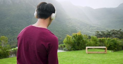 Person with Headphones Gazing at Serene Mountain Landscape