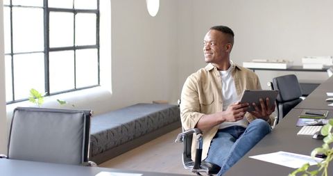 Smiling Businessman Holding Tablet in Contemporary Office Environment