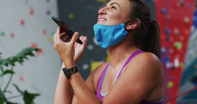 Smiling Woman Enjoying Phone Call at Indoor Climbing Gym - Download Free Stock Images Pikwizard.com