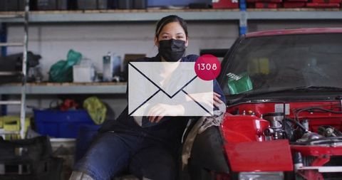 Female mechanic in workshop with envelope icon overlay